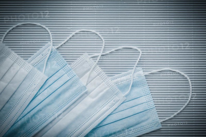 Set of disposable medical flu masks on a striped background