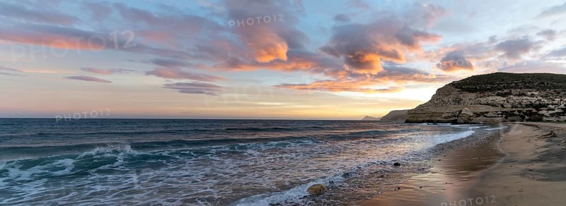 A beautiful panorama ocean sunset on the Costa del Sol in Spain with beach and cliffs in the background