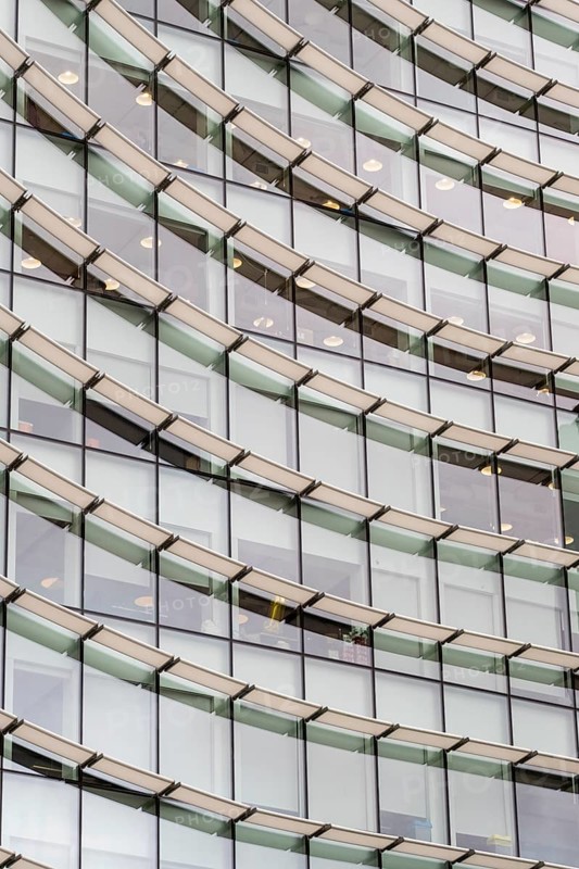 Abstract mosaic of geometric shapes adorns the modern building's facade, doubling as a captivating backdrop, creating a mesmerizing repetitive pattern