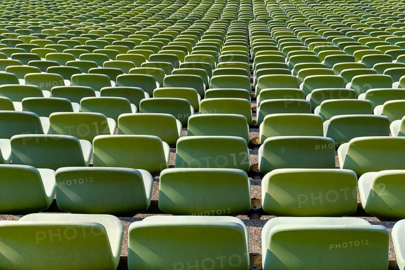 Many endless rows of enpty chairs in a stadium