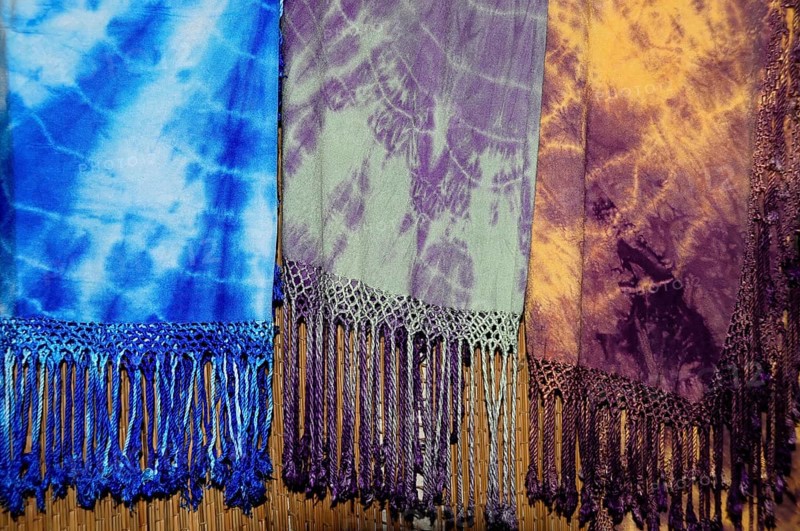 Fes, Northern Morocco, Morocco, Africa, Colourful batik scarves with fringes in blue, purple and yellow hang next to each other, Africa