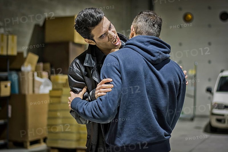 Close up Hungry Young Male Vampire with Scary Facial Expression Bites the Neck While Holding a Man
