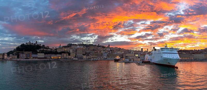 Ancona, Italy, 24 November, 2022: panorama view of the old town and harbor of Ancona with a large cruise ship at the docks at sunrise, Europe