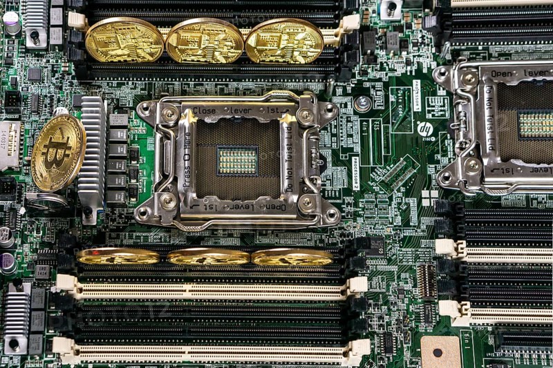 Golden Bitcoin Cryptocurrency on computer circuit board. Blockchain and security concept