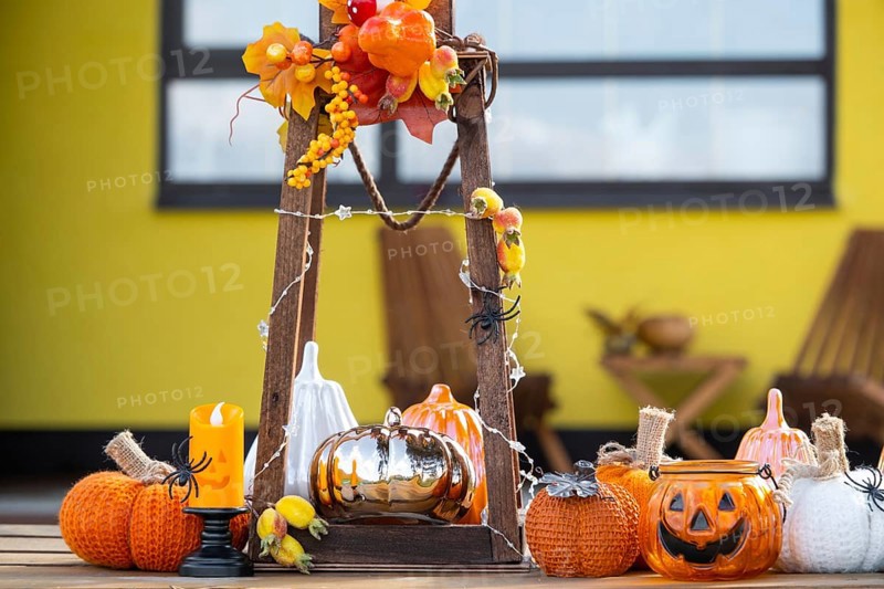 Autumn decor on the porch of the house outside in the yard of pumpkin, lantern, garlands, hats, jack lantern. Halloween party, autumn mood, Harvest festival
