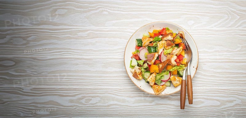 Traditional Levant dish Fattoush salad, Arab cuisine, with pita bread croutons, vegetables, herbs. Healthy Middle Eastern vegetarian salad, rustic wooden white background top view, food photography, food photography