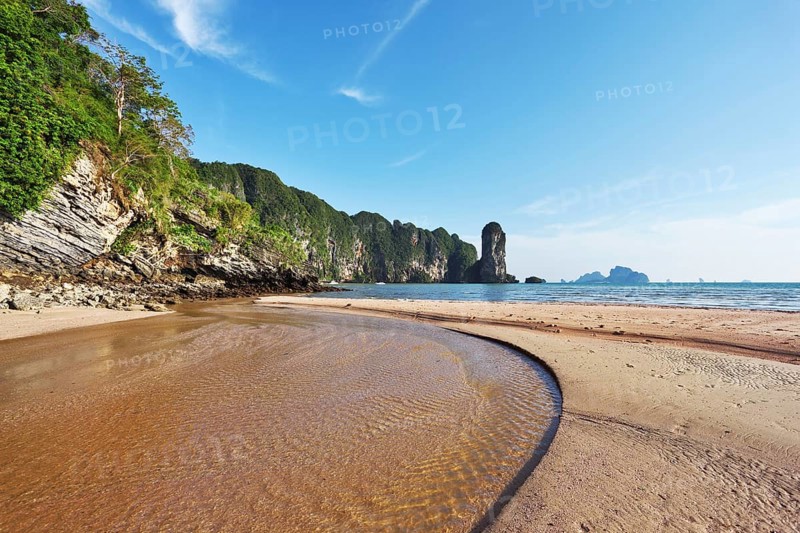 The beach at low tide. A huge puddle of sea water and bright orange sand