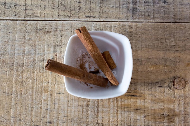 Pair of cinnamon sticks in a white bowl