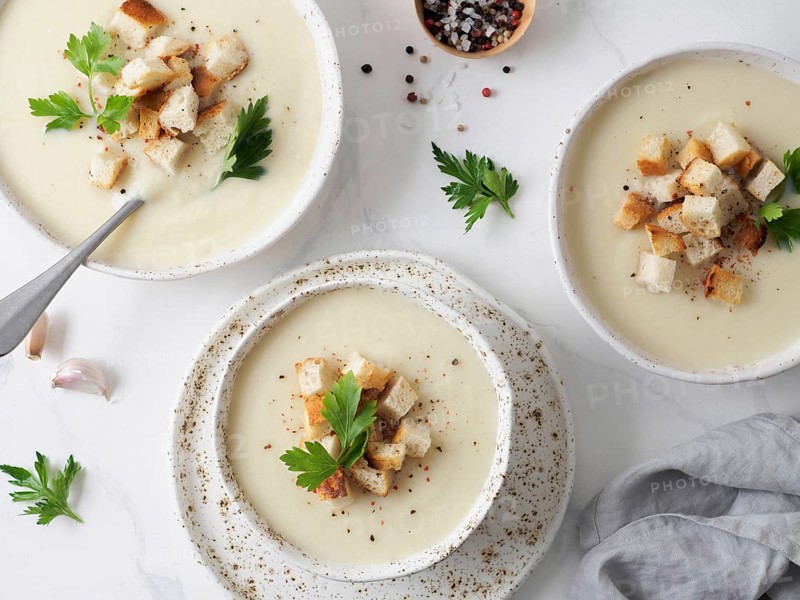 Cauliflower potato soup puree on white marble tabletop, Creamy cauliflower soup with toasted bread croutons. Vegetarian healthy food concept. Ideas and recipes for winter meal. Top view or flat lay