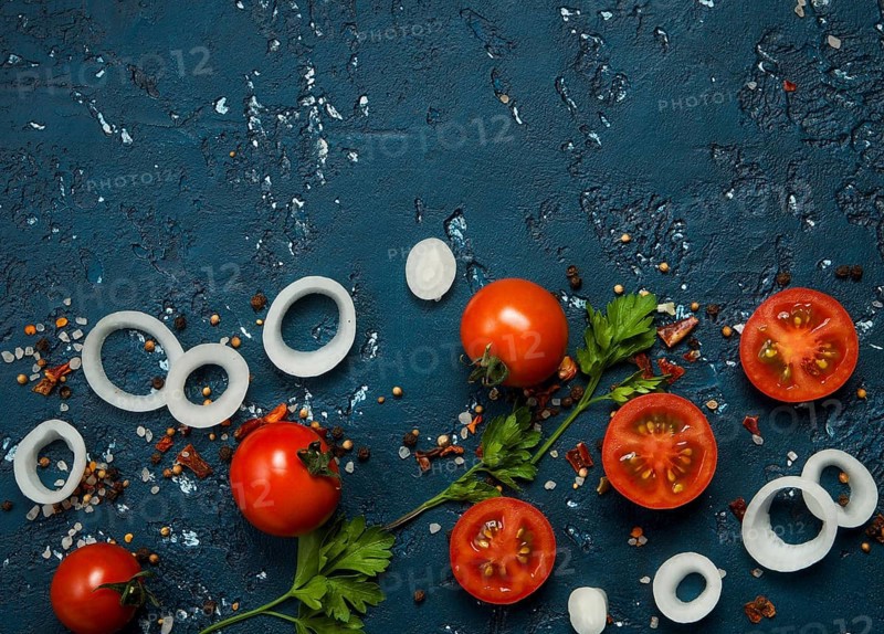 Vegetables background. Fresh vegetables (garlic, tomatoes, onions) on a dark embossed surface. View from above. Copy space