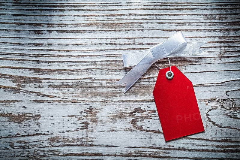 Red sale tag on vintage wooden board top view
