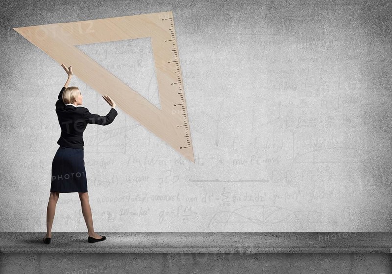 Woman holding big ruler on wall background. Testing and examination concept. Businesswoman measuring something with ruler. Human resources recruitment. Creative motivation, coaching and mentoring