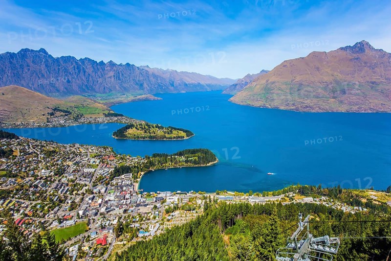 Huge azure lake among the mountains. Bird's eye view. Travel to New Zealand, South Island. The city - resort Queenstown, shores of Lake Wakatipu. The concept of active, ecological and photo tourism