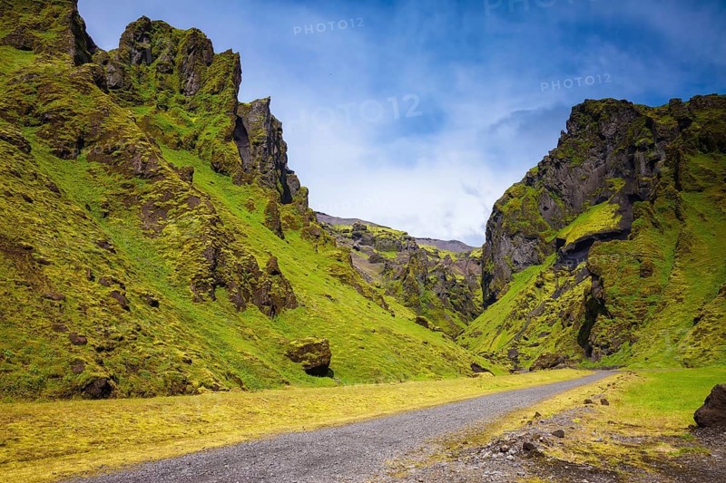 Canyon Pakgil - green grass and moss on fantastic rocks. On canyon there is dirt road. The summer Iceland
