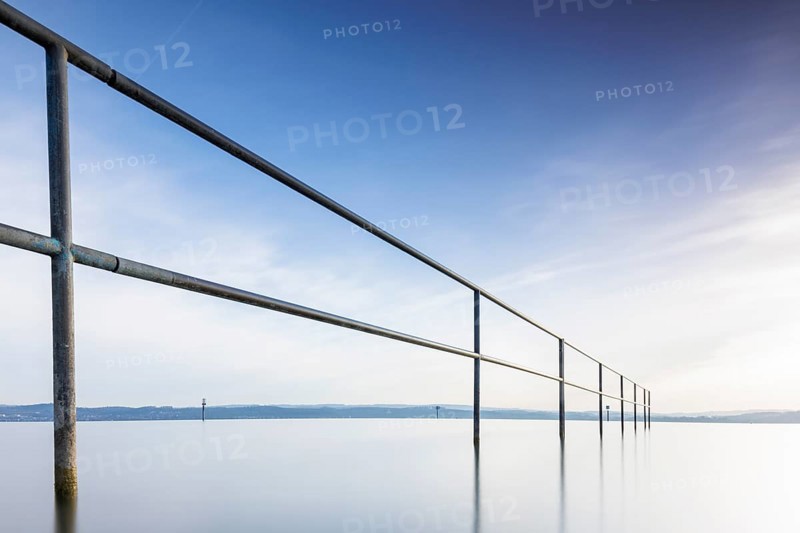 A railing in front of a calm, blue sky and lake, lido, Litzelstetten, Lake Constance, Baden-Württemberg, Germany, Europe