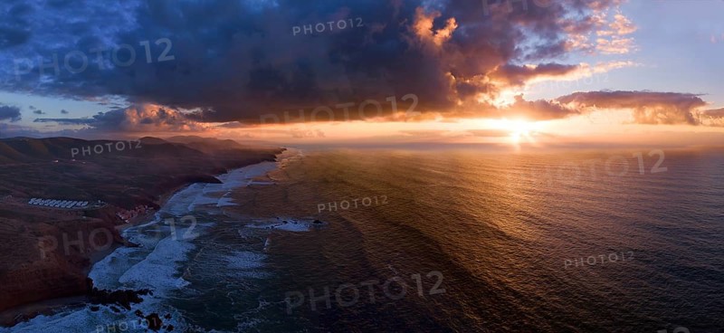 Aerial panorama of Legzira beach with arched rocks on the Atlantic coast at sunset in Morocco