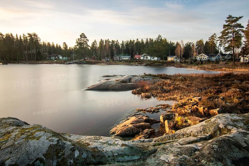 Shore of a lake at sunrise. Landscape shot in Narur in the morning. Forests, lake and water at the beginning of winter or in autumn. Sweden, Scandinavia
