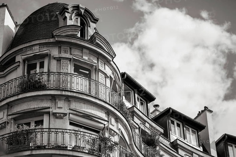 Details of a residential building with curved walls, balconies and ornate iron railings in Paris, France, Europe
