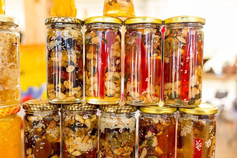 Honey with dried fruits and dried nuts - walnuts, hazelnuts, peanuts, almonds, cashews, plums, cherries, apples, figs and dates