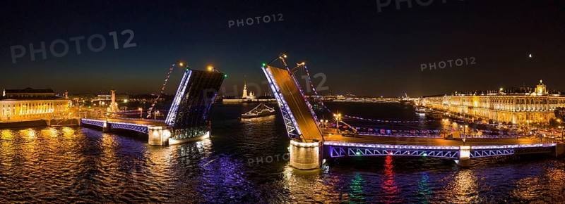 Aerial panorama of the drawn Palace bridge, Winter Palace, Peter and Paul Fortress and Rostral Columns in St. Petersburg at night, Russia, Europe