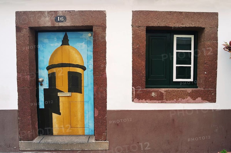 House wall with colourfully painted door, Madeira