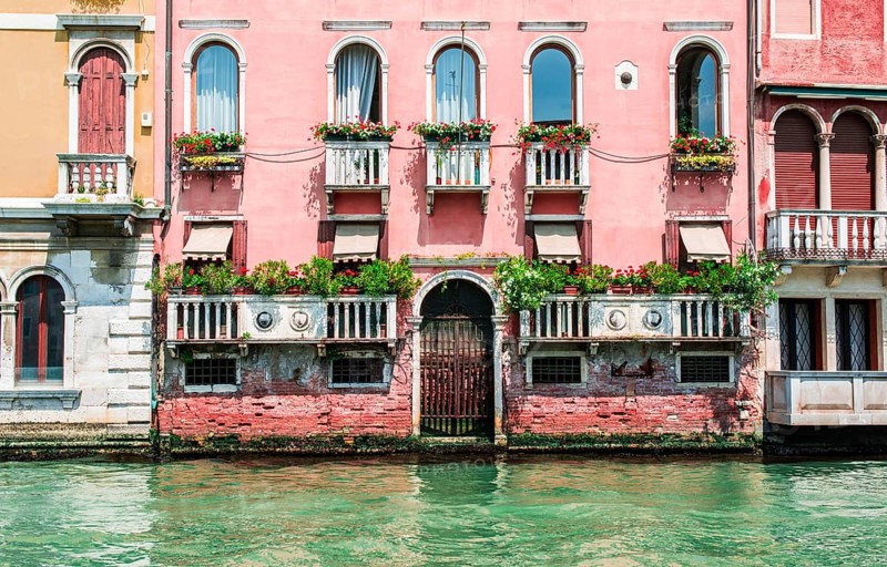 Ancient buildings in Venice. Boats moored in the channel. View from the side of the water