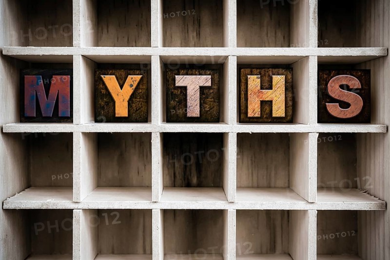 The word MYTHS written in vintage ink stained wooden letterpress type in a partitioned printer's drawer