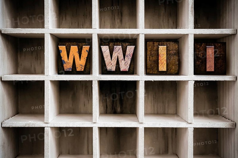 The word WWII written in vintage ink stained wooden letterpress type in a partitioned printer's drawer