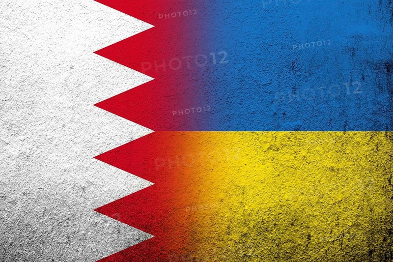 The Kingdom of Bahrain national flag with National flag of Ukraine. Grunge background