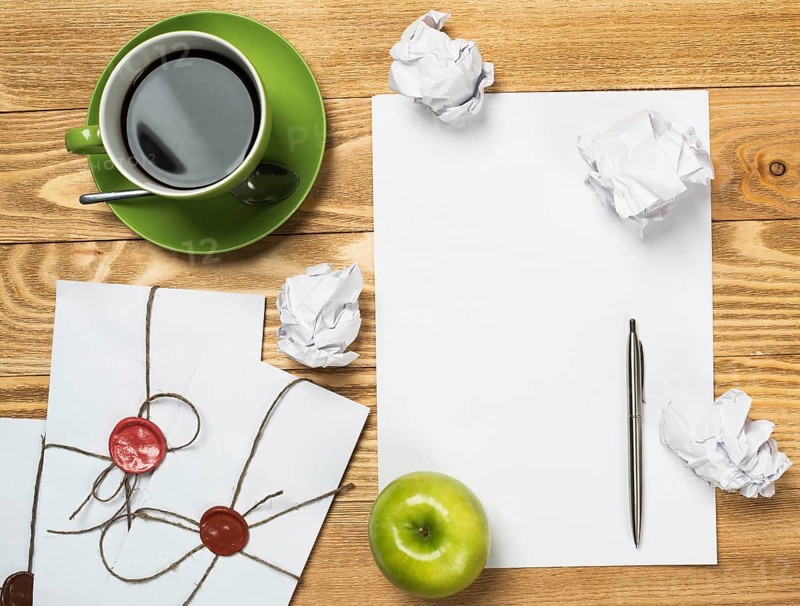 Top view of creative writing concept with papers on wooden table