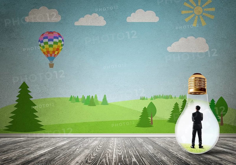 Businessman inside light bulb in room against nature drawn concept