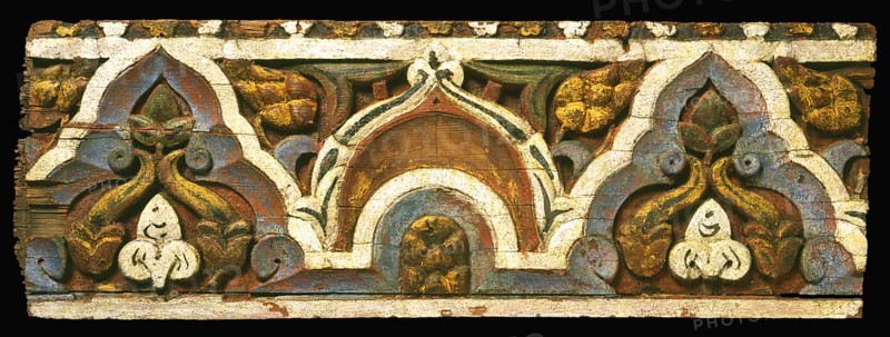 The panel's pattern achieves a fine balance between serving as a geometric border and comprising a vegetal ornament with recognizable elements such as pinecones and leaves. The wooden panel perhaps embellished a lintel in a well-to-do private house