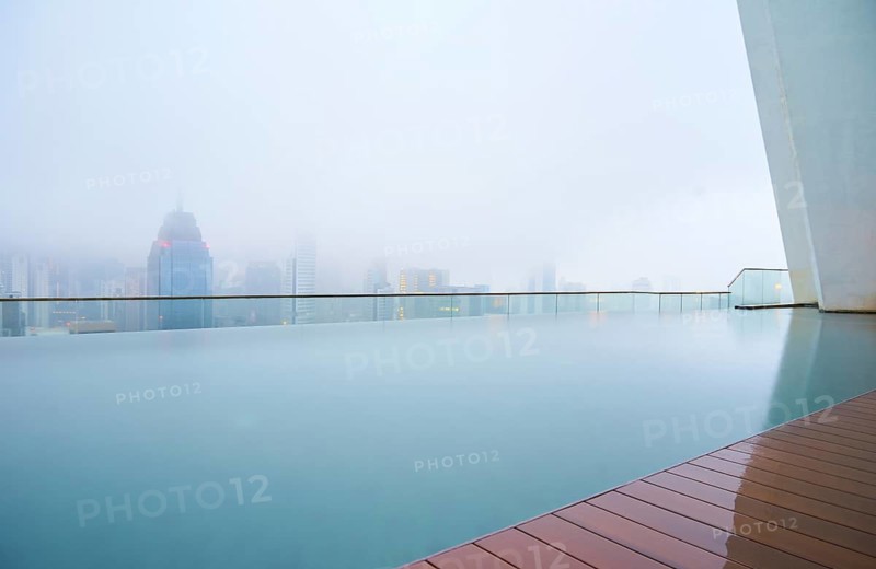 Swimming pool on roof top with beautiful city skyline view, early morning with mist, kuala lumpur malaysia