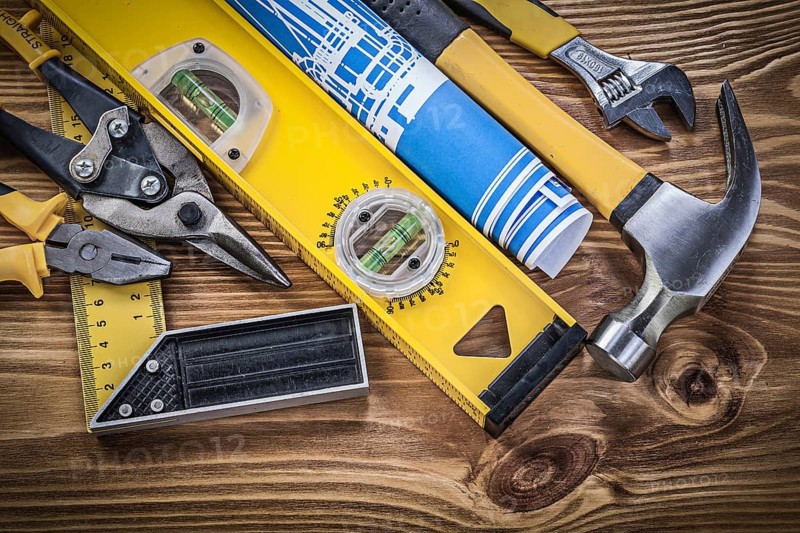 Collection of construction tools on wooden board top view