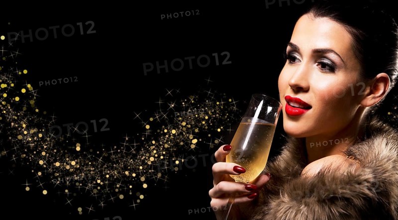 Romantic woman with golden makeup and nailpolish. Big gold fashion necklace. Black isolated background. Holding glass of champagne, Toronto, Canada, North America