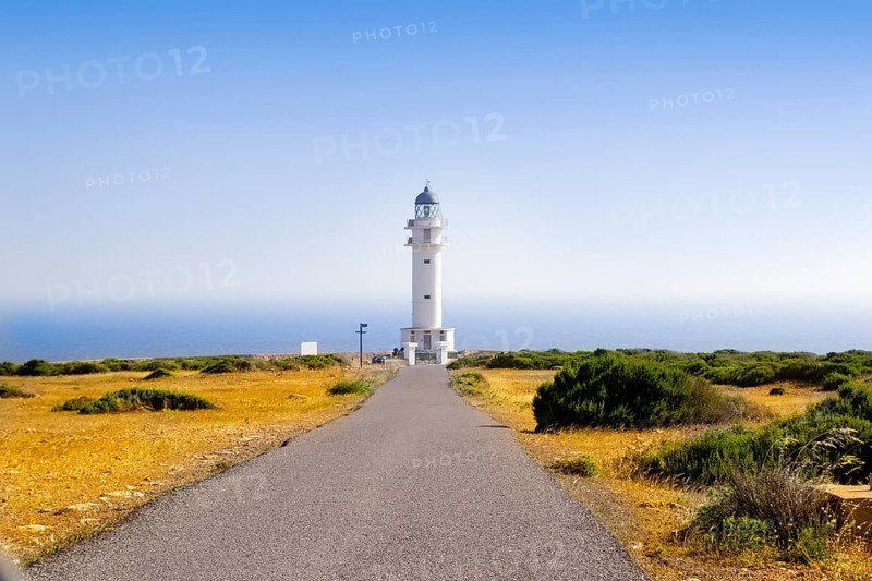 Barbaria Lighthouse cape Formentera Balearic Islands in golden grass meadow blue sky