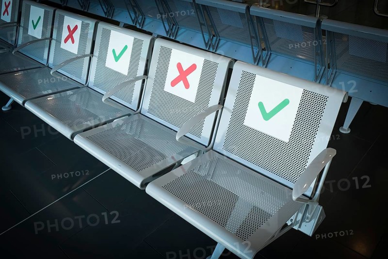 Empty chairs on an airport terminal with signs to keep social distance for the preventions of coronavirus covid 19 spread
