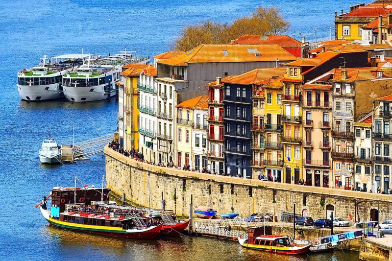 Porto, Portugal old town ribeira aerial promenade view with colorful houses, Douro river and boats