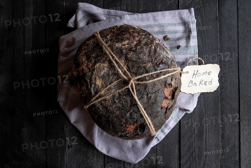 Fresh baked homemade bread on a black wooden table. Above view image