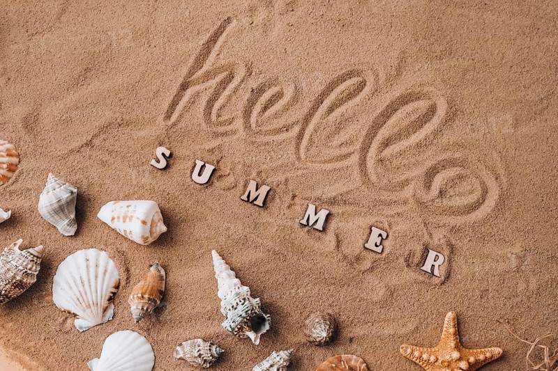 Composition with text HELLO SUMMER seashells, pebbles, mockup on sand background. Blank, top view, still life, flat lay. Sea vacation travel concept tourism and resorts. Summer holidays