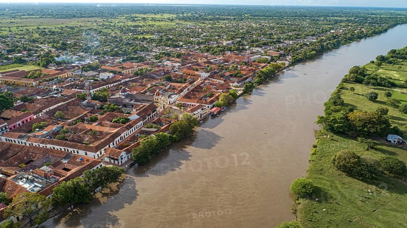 Aerial view of the historic town Santa Cruz de Mompox in sunlight with river and green sourrounding, World Heritage