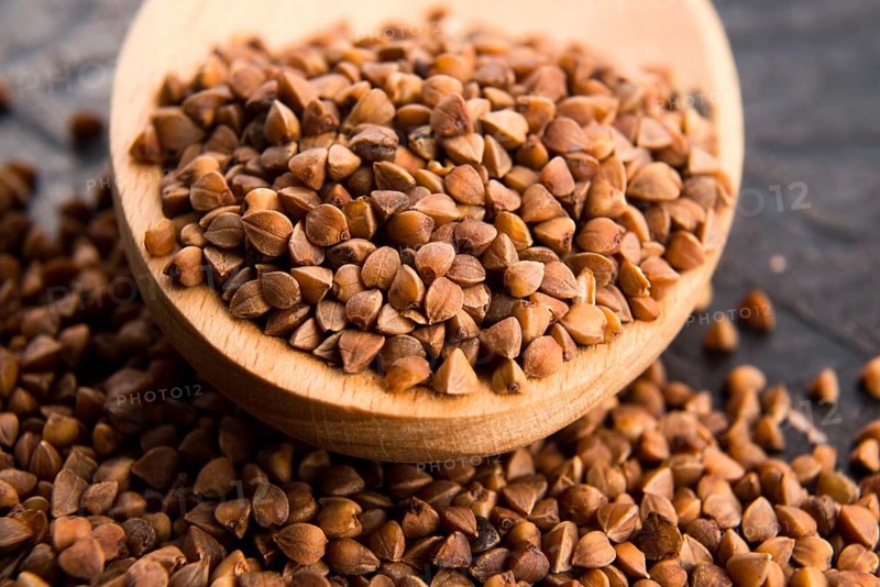 Buckwheat seeds on wooden spoon in closeup, lodz, poland