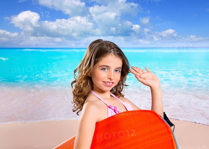 Children fashion surfer girl in tropical turquoise beach vacation with greeting hand