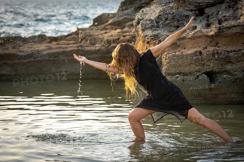 Middle-aged woman dancing and throwing water in the air, Maioris beach, llucmajor, Majorca, Balearic Islands, Spain, Europe