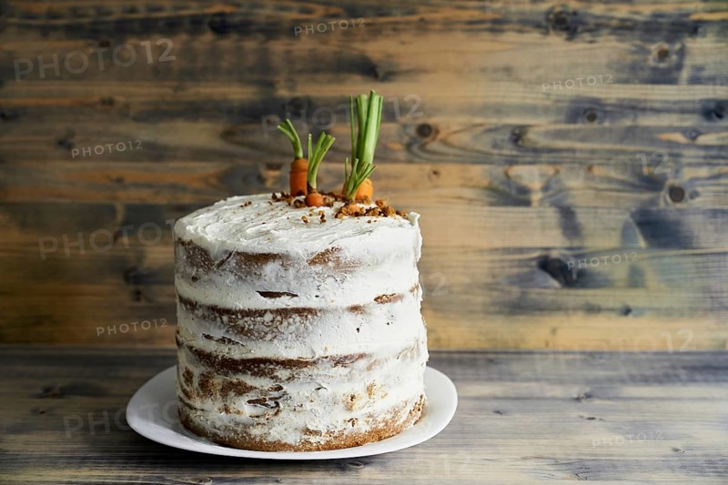 Carrot cake on a plate on wooden background.