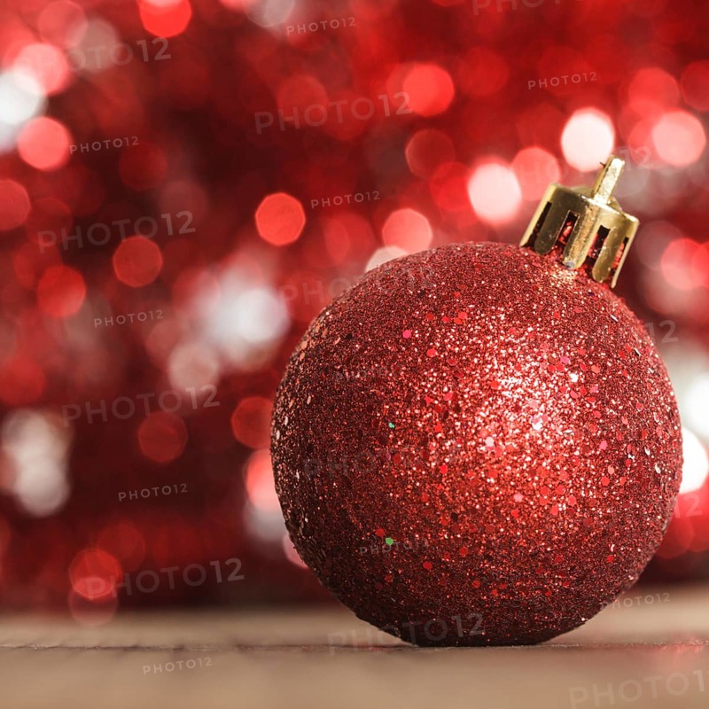 A red christmas bauble on the background of red boken