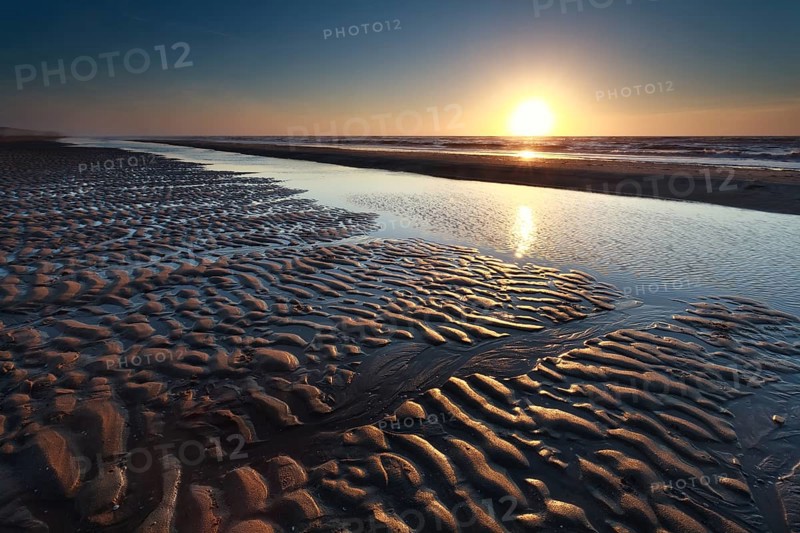 Sand beach at low tide and sunset, North Holland, Netherlands
