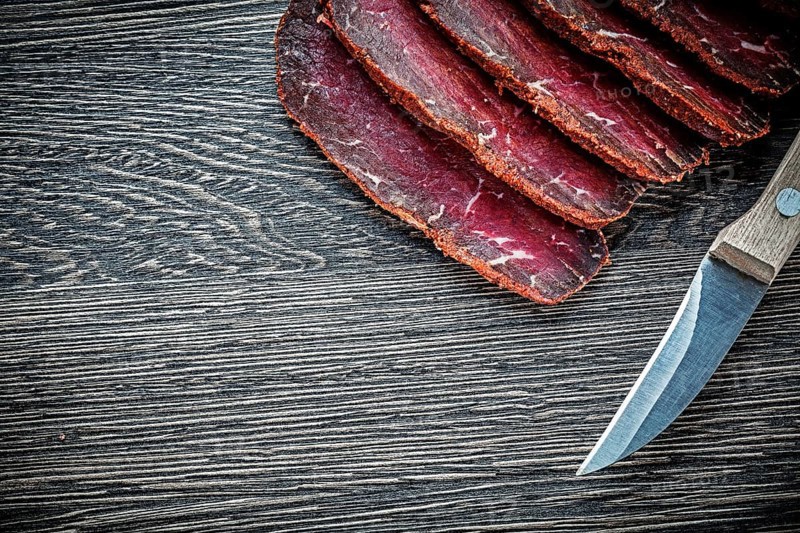 Sliced meat knife on wooden board