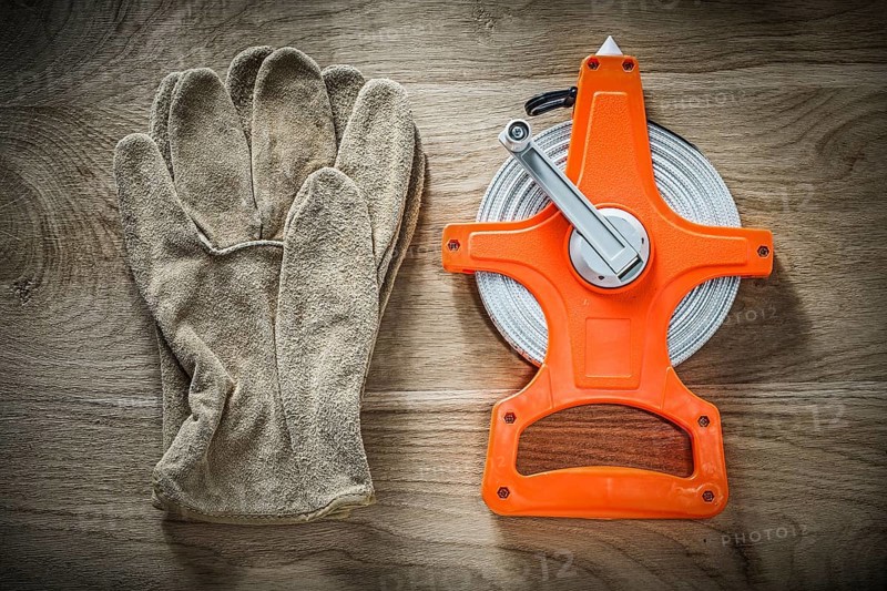 Safety gloves measuring tape on wooden board