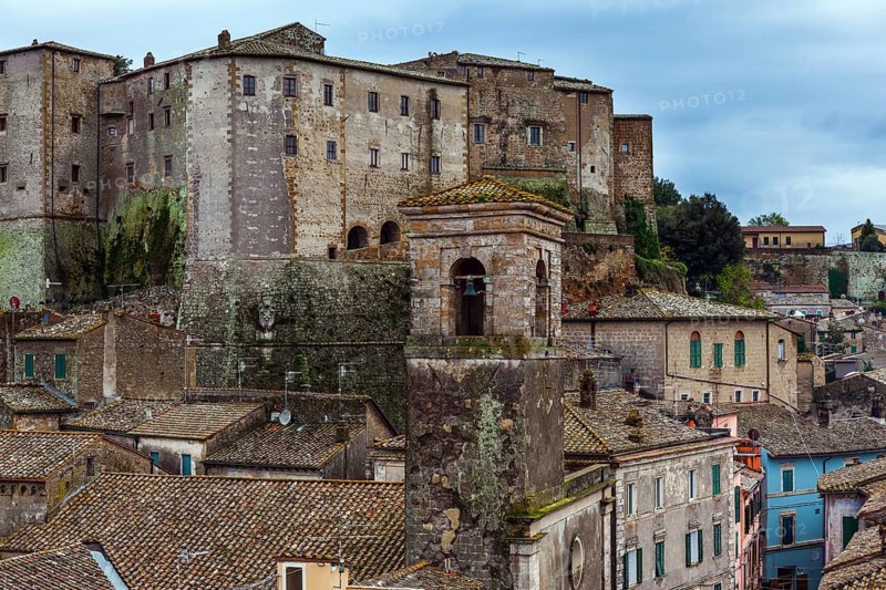Italy, southern Tuscany. The tufa city of Sorano is a enchanted city from a fairy tale. Tiled roofs of houses, narrow streets amidst gloomy stone walls. The concept of active, historical and photo tourism, Europe